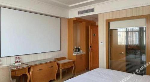 a bedroom with a large projection screen on the wall at Vienna Hotel Guangdong Huiyang Qiuchang Yingbin Road in Huizhou