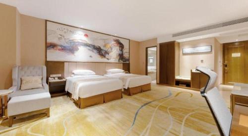a hotel room with two beds and a couch at Venus Royal Hotel Nanning East High-Speed Railway Station in Nanning