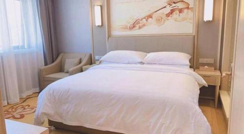 a bedroom with a large white bed and a chair at Vienna Hotel Zhejiang Lishui Qingtian Post Building in Lishui
