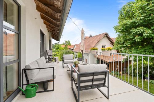 a patio with chairs and a table on a balcony at Fe Wo Brunnen - 120 qm - ruhige Lage - viel Natur- komfortabel - grosser Balkon und Garten - 3D Rundgang verfügbar in Memmingen