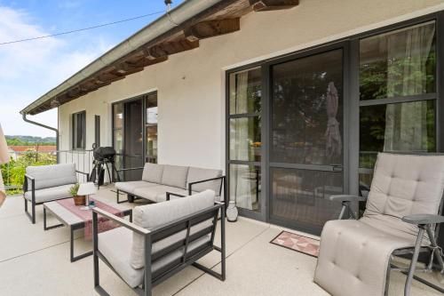 a patio with chairs and a table and windows at Fe Wo Brunnen - 120 qm - ruhige Lage - viel Natur- komfortabel - grosser Balkon und Garten - 3D Rundgang verfügbar in Memmingen