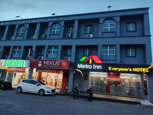 a white car parked in front of a building at Metroinn Hotel in Arau