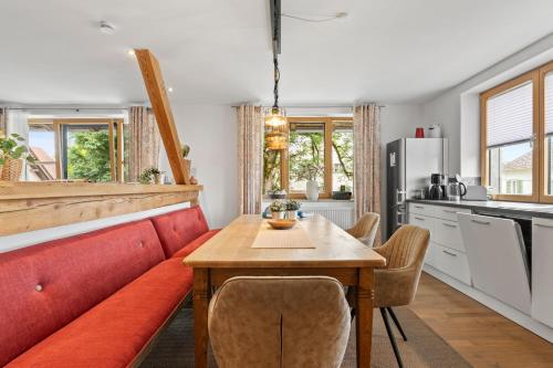 a kitchen with a table and a red couch at Fe Wo Brunnen - 120 qm - ruhige Lage - viel Natur- komfortabel - grosser Balkon und Garten - 3D Rundgang verfügbar in Memmingen