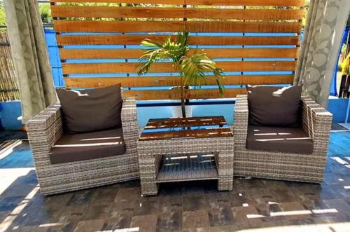 two wicker chairs and a table on a patio at Hidden Palms Inn & Resort Quadruple in San Juan