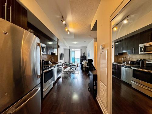 a kitchen with a stainless steel refrigerator and wooden floors at Prime Location with Stunning Views and Free Parking in Vaughan