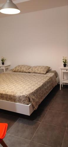 a bed in a white room with two white tables at Tsampikas House in Faliraki