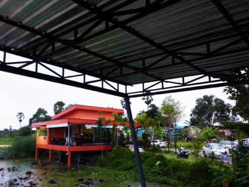 a gas station with a red roof with cars parked at BanRai ChernMa Resort in Tak