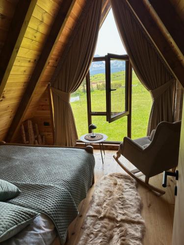 a bedroom with a bed and a large window at Zen house 1 Zabljak in Žabljak