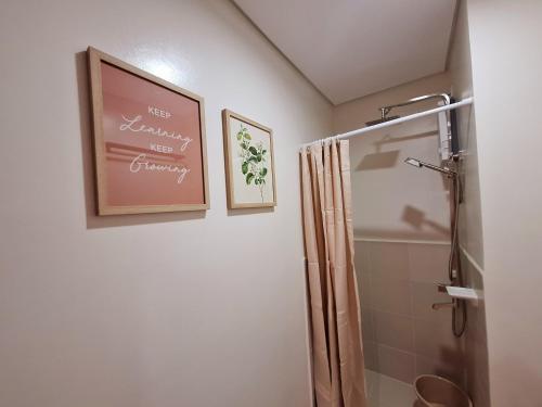 a bathroom with a shower and a picture on the wall at GTG RMJ Hills Residences in Manila