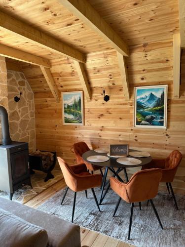 a living room with a fireplace and tables and chairs at Zen house 1 Zabljak in Žabljak