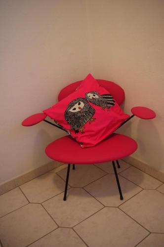 a red chair with two pillows on top of it at Apartments Lux in Makarska