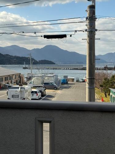 a view of a parking lot with a view of the water at Itoshima inn 海 山 川が目の前でベッド8台 4LDK 一棟貸し in Itoshima