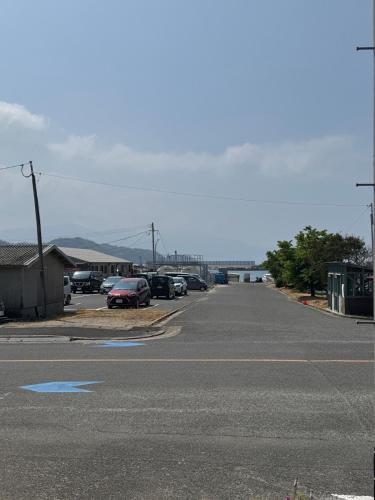 an empty street with cars parked in a parking lot at Itoshima inn 海 山 川が目の前でベッド8台 4LDK 一棟貸し in Itoshima