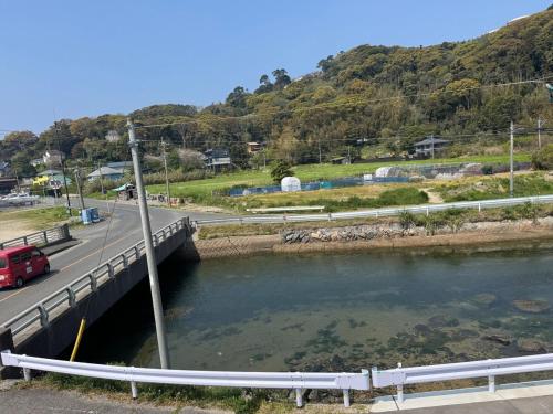 a bridge over a river next to a road at Itoshima inn 海 山 川が目の前でベッド8台 4LDK 一棟貸し in Itoshima