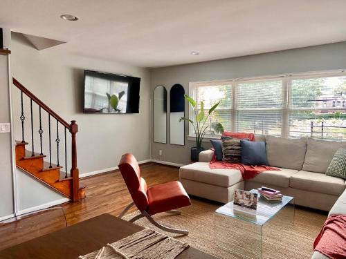 a living room with a couch and a table at Easy PATH&Bus access- NYC| designer home + Deck. in Jersey City