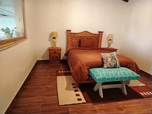 a bedroom with a bed and a chair in it at Hermosa Cabaña en San Pedro Atlapulco in San Pedro Atlapulco