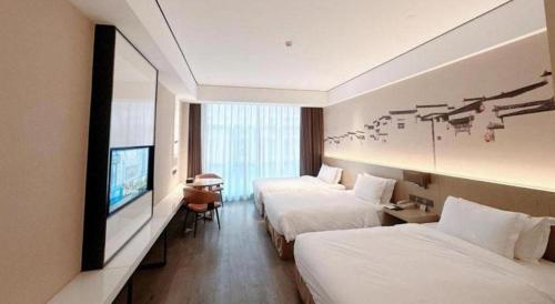 a hotel room with two beds and a flat screen tv at GRACE Select Hotel (Kunshan Huaqiao International Convention Center) in Suzhou