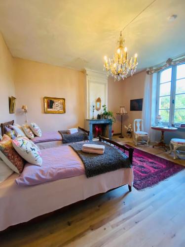 une chambre avec un grand lit et un lustre dans l'établissement Chateau Ciers, à Saint-Ciers-sur-Gironde