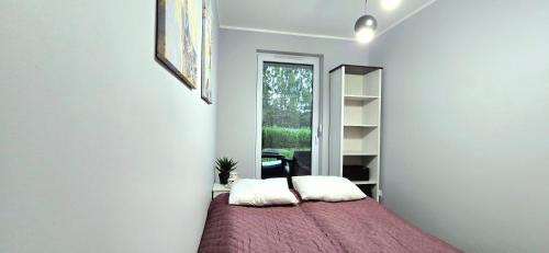 a bedroom with a bed with two pillows on it at Apartament Gwiazda Morza Jantar by TriApart in Jantar
