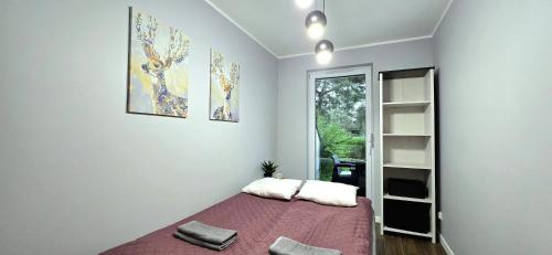 a bedroom with a bed with two pillows on it at Apartament Gwiazda Morza Jantar by TriApart in Jantar