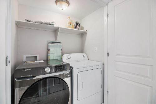 a small laundry room with a washer and dryer at Luxurious Tastefully Furnished 3 bedroom Home in Ottawa in Ottawa