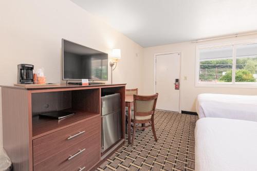 a hotel room with a television and a bed at Econo Lodge Cherokee Near Island Park in Cherokee
