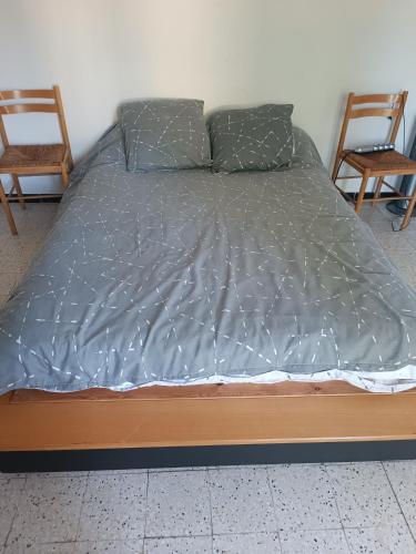 - un lit dans une chambre avec 2 chaises dans l'établissement Les cevennes depuis le vigan, au Vigan