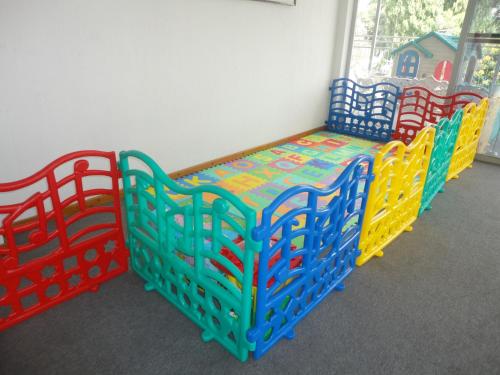 a childrens play room with a bed and chairs at Jóia Hotel in Poços de Caldas