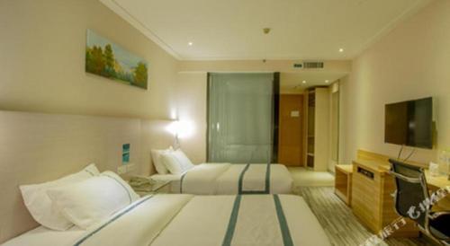 a hotel room with two beds and a television at City Comfort Inn Nanning Zoo Keyuan Avenue in Nanning