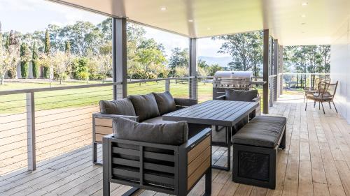 a screened in porch with a table and a grill at Coopers Lodge, Lovedale - A rural escape in the heart of wine country in Lovedale