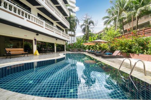 a swimming pool next to a building with a resort at Patong Central Residence and Apartment in Patong Beach