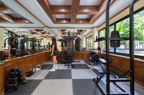 a gym with two women working out in the gym at Patong Central Residence and Apartment in Patong Beach
