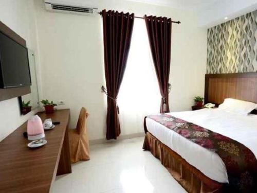 a bedroom with a bed and a large window at Hotel Grand Permata Hati in Banda Aceh