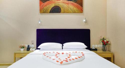 a heart shaped pillow on a bed in a bedroom at The Bauhinia in Shenzhen