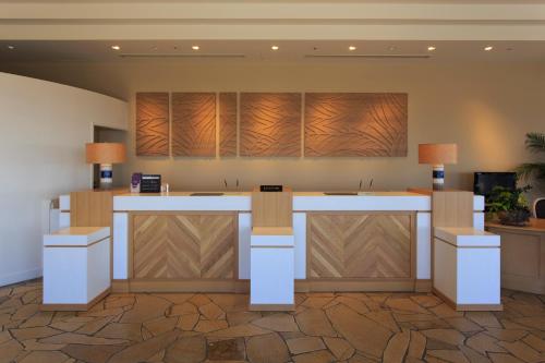 an office lobby with a reception counter with wood panels at Yumihari-no-Oka Hotel in Sasebo
