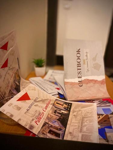 a table topped with paper bags and magazines at Palazzo Cambiaso Albergo Etico Genova in Genova