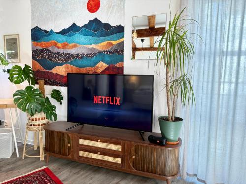 a tv sitting on a wooden stand in a living room at Charmantes Altstadtzimmer mit Teeecke & Arbeitsplatz Come In in Esslingen
