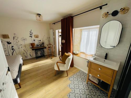 a bathroom with a sink and a mirror at La petite maison d a cote in Champniers
