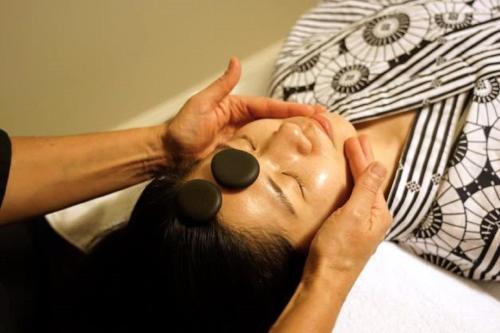 a man with glasses on his face laying on a bed at Shizuka Ryokan Japanese Country Spa & Wellness Retreat in Hepburn Springs