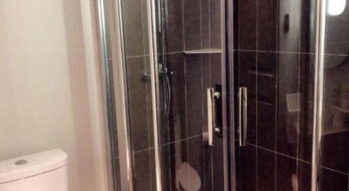 a bathroom with a glass shower with a toilet at Ibis Nantong Qingnian in Nantong
