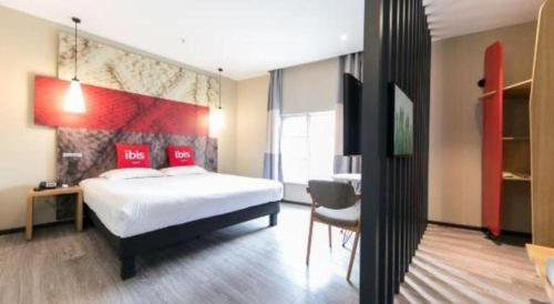 a bedroom with a bed and a desk and a chair at Ibis Nantong Qingnian in Nantong