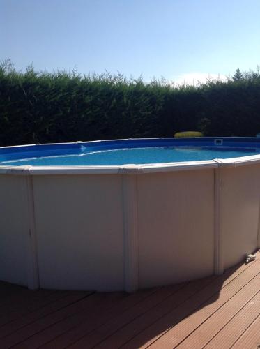 a hot tub with a blue top on a deck at MAISON PRIVÉE AVEC PISCINe in Beaurepaire