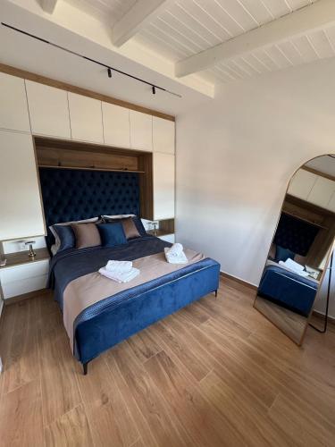 a bedroom with a blue bed and a mirror at Vitamine Luxury Apartments 2 in Sarandë