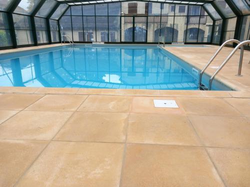 - une piscine avec du carrelage dans un bâtiment dans l'établissement Lacampana106, à Bielle