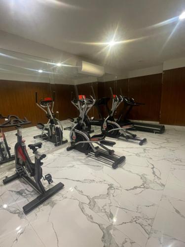 a group of exercise bikes in a room with a marble floor at Bujalux apartment in Muscat