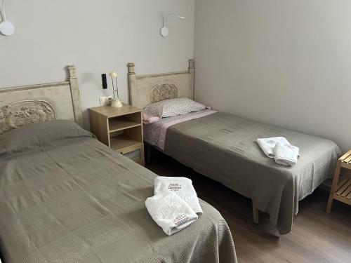 a bedroom with two beds and a table with towels at Creu St Pol G5 Terraza y vistas junto a la playa in S'Agaro