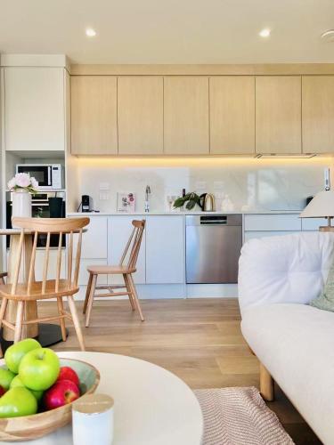 a kitchen and living room with a bowl of fruit on a table at 8 Ocean Rd in Auckland