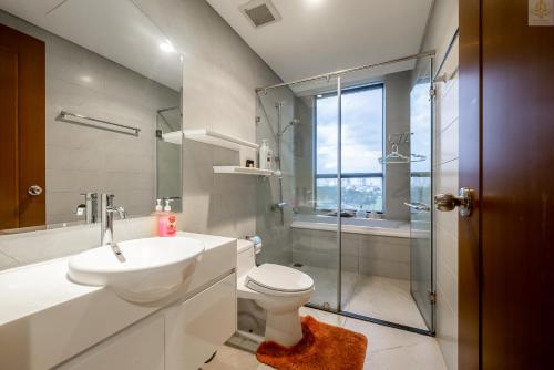 a bathroom with a toilet and a sink and a shower at Landmark Plus Vinhomes CityView Suite in Ho Chi Minh City