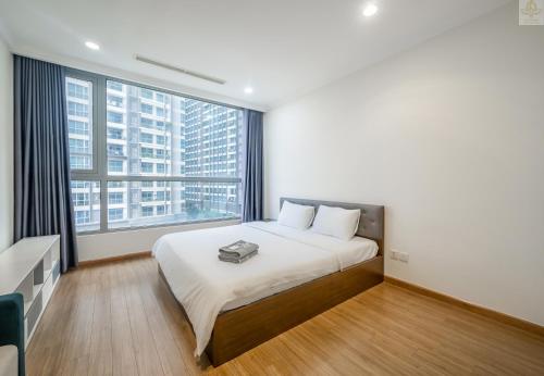 a bedroom with a large bed with a large window at Landmark Plus Vinhomes CityView Suite in Ho Chi Minh City