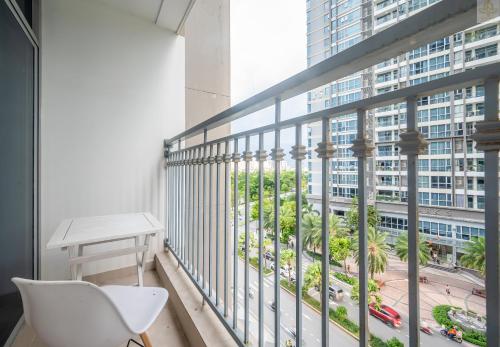 a balcony with a white chair and a view of a city at Landmark Plus Vinhomes CityView Suite in Ho Chi Minh City